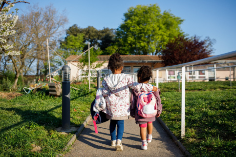 Deux élèves de dos se dirige vers l'école