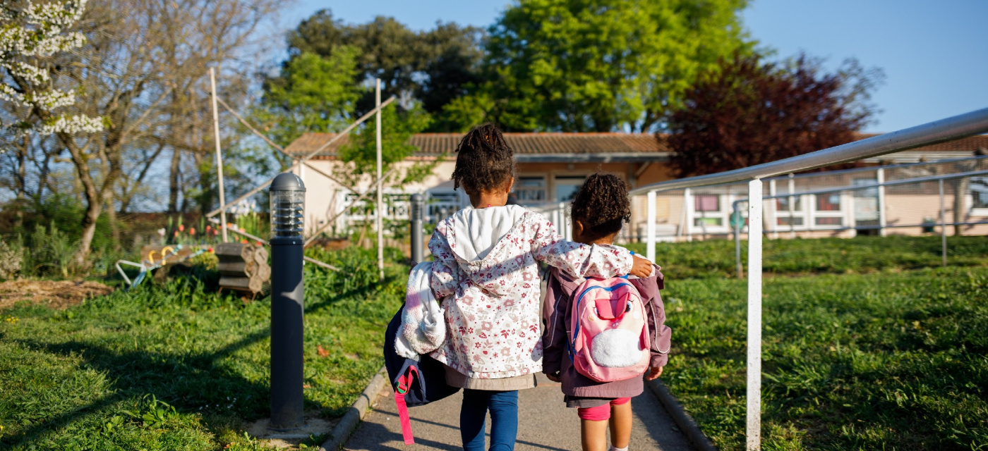 Deux élèves de dos se dirige vers l'école