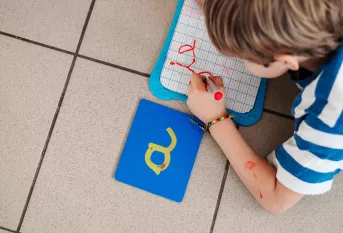 Enfant qui écrit sur une ardoise