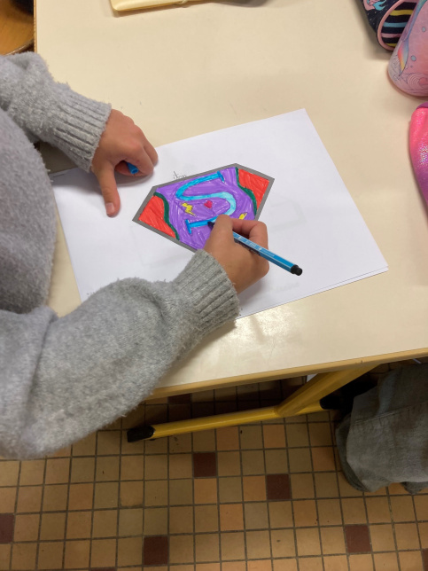 Elève dessine son logo de super-héros