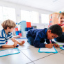 Des enfants font des exercices sur une ardoise