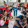 Des enfants assis en rond écoutent une professeure